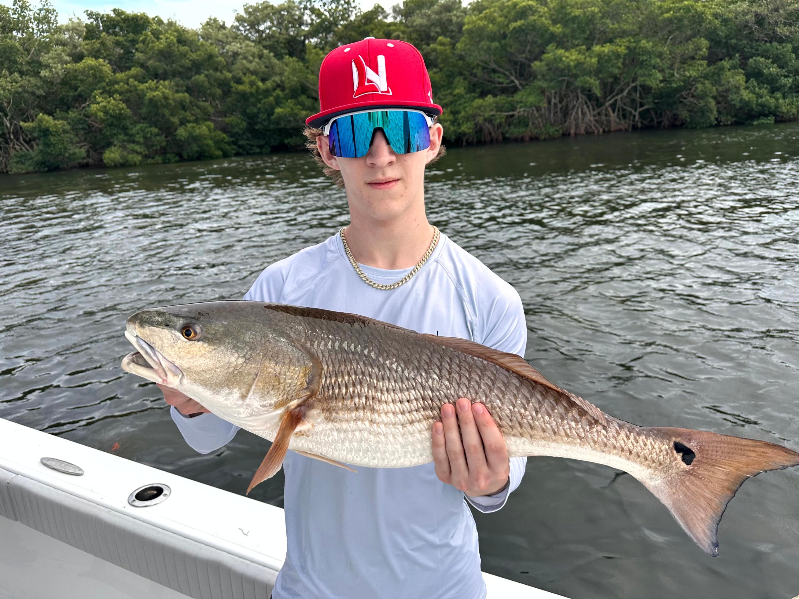 Early morning fishing charter in Tampa Bay with anglers catching fish at sunrise