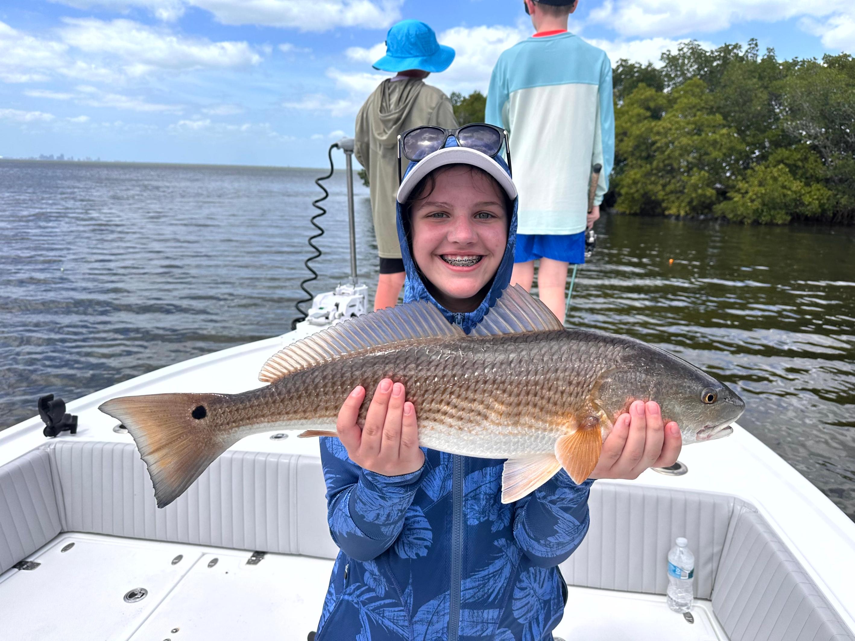 Kids having fun on a Tampa Bay fishing charter, catching fish and making family memories