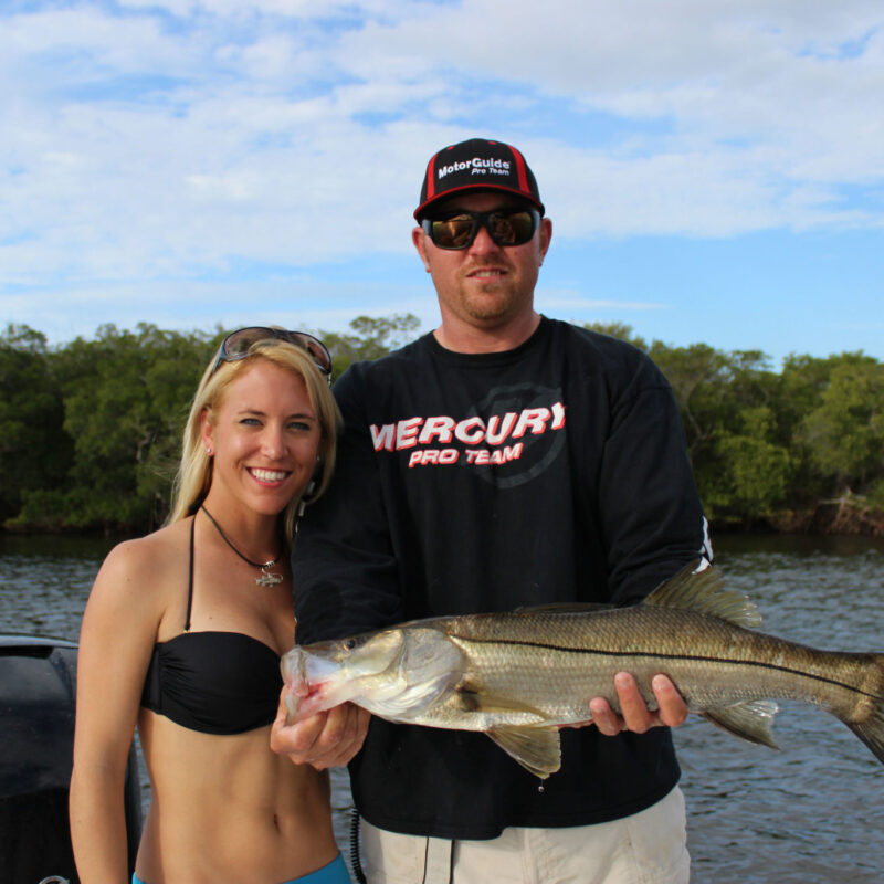 male and female holding a snook